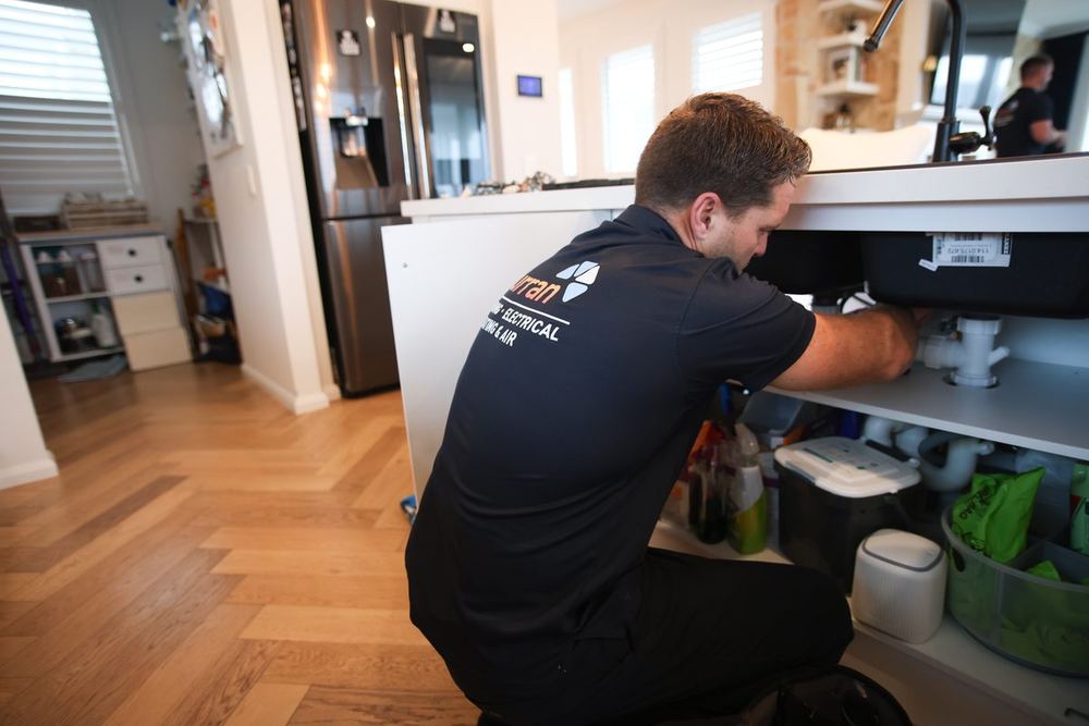Curran plumber repairing a kitchen sink in a local home